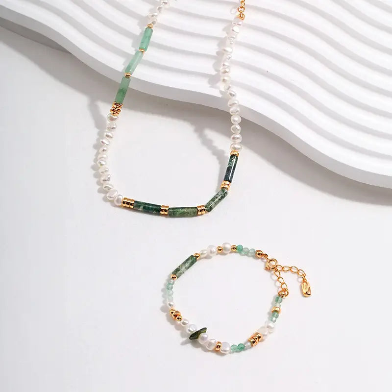 Half-and-half pearl and green crystal necklace with matching gold-accent bracelet.