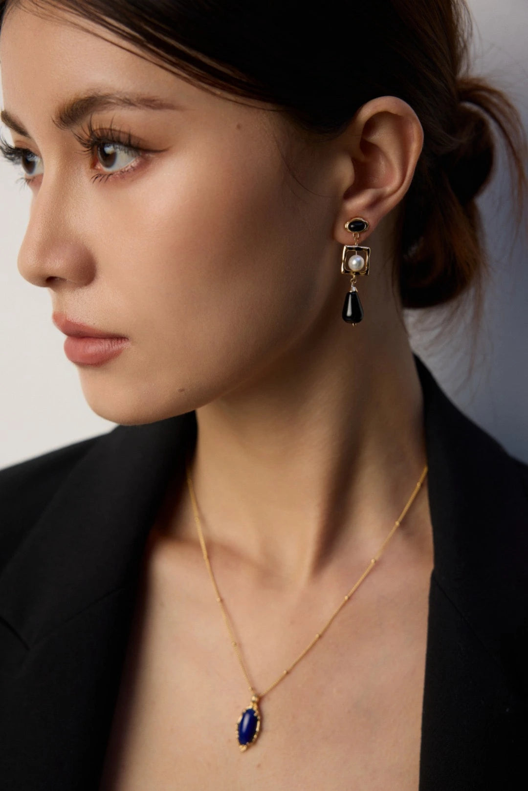 Woman in Celeste necklace and black pearl earrings, showcasing lapis lazuli detail