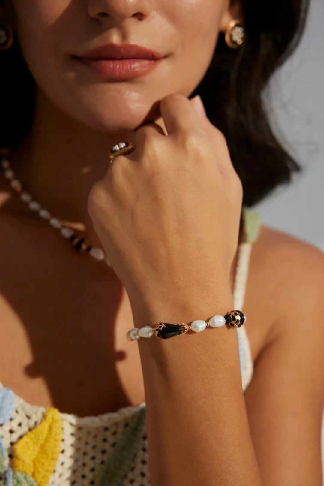 Close-up of Anaïs & Aimee Black Obsidian Pearl Bracelet with gold accents on model’s wrist