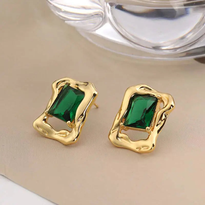 Emerald Crystal Stud Earrings with green emerald-cut stones in gold-tone irregular frames