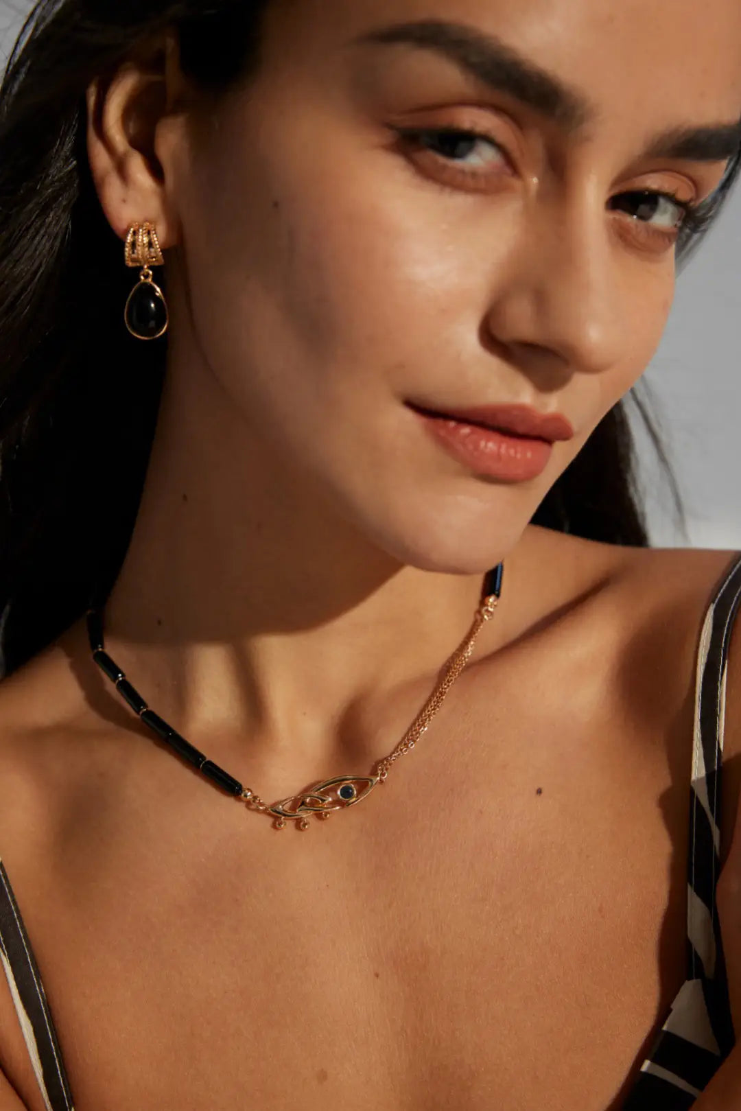 Model wearing Anaïs & Aimee gold Evil Eye Black Obsidian Necklace with modern style