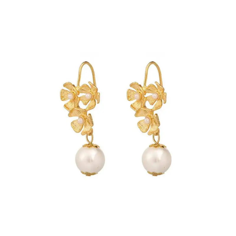 Elegant gold floral earrings with detailed petals, small pearls, and a large pearl drop.