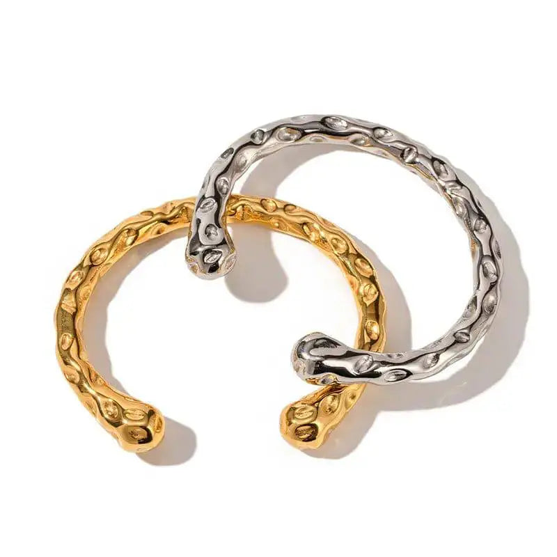 Hammered gold and silver bracelets with organic texture displayed on white background