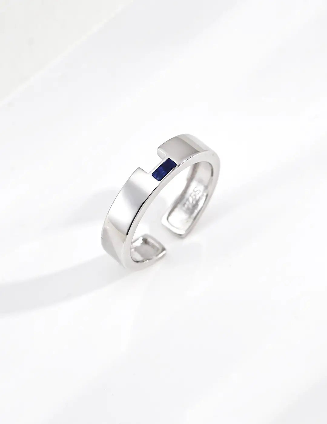 Silver ring with a blue gemstone on a white background