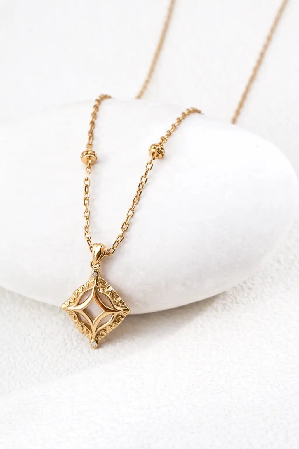 Close-up of Haslemere gold square pendant necklace with mother of pearl centre and zircon detail on a delicate adjustable chain.