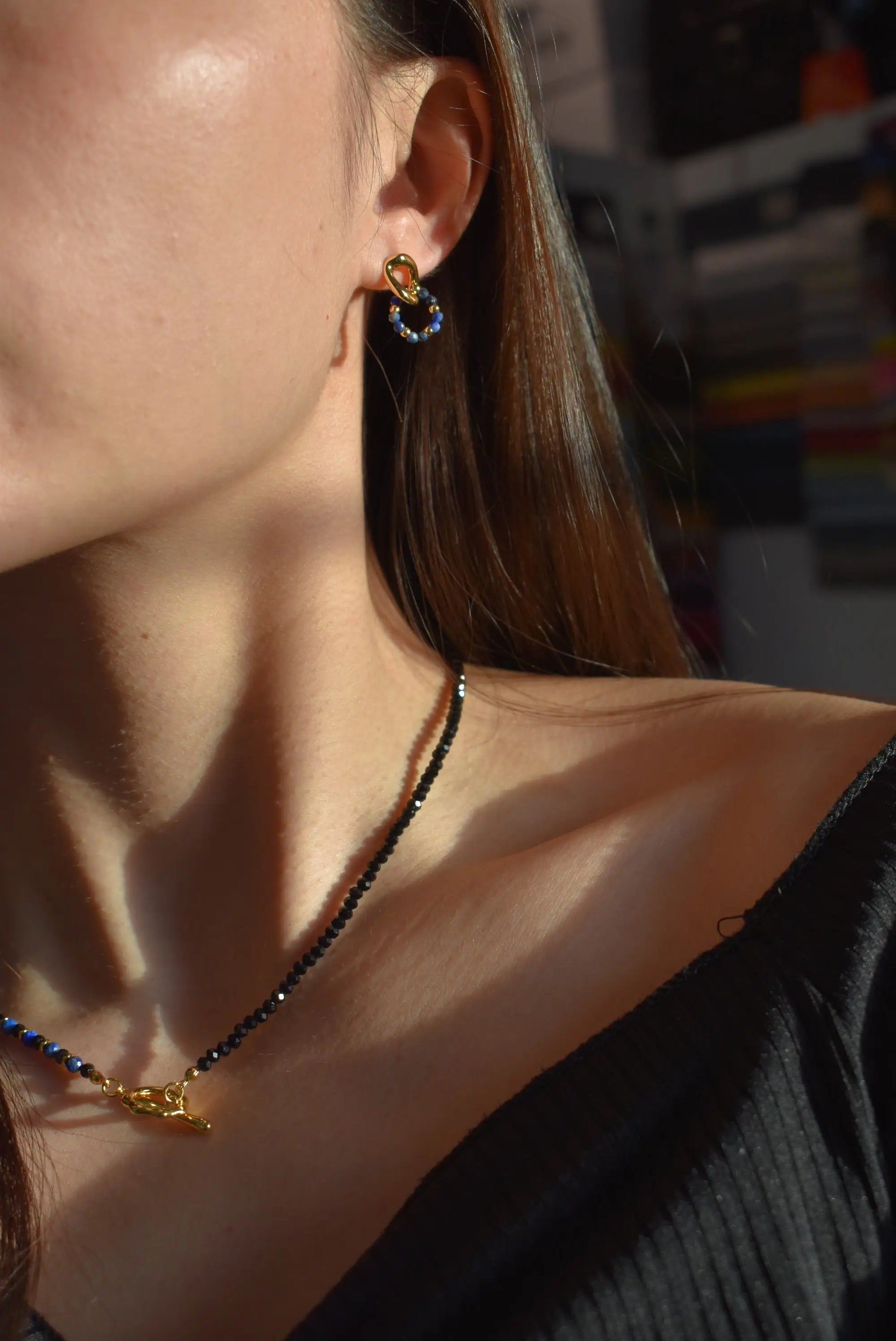 Model wearing Lapis Lazuli Black Spinel Necklace and matching earrings on collarbone