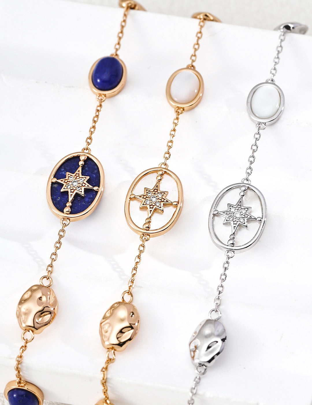 Three gold and silver necklaces with star designs on a white background