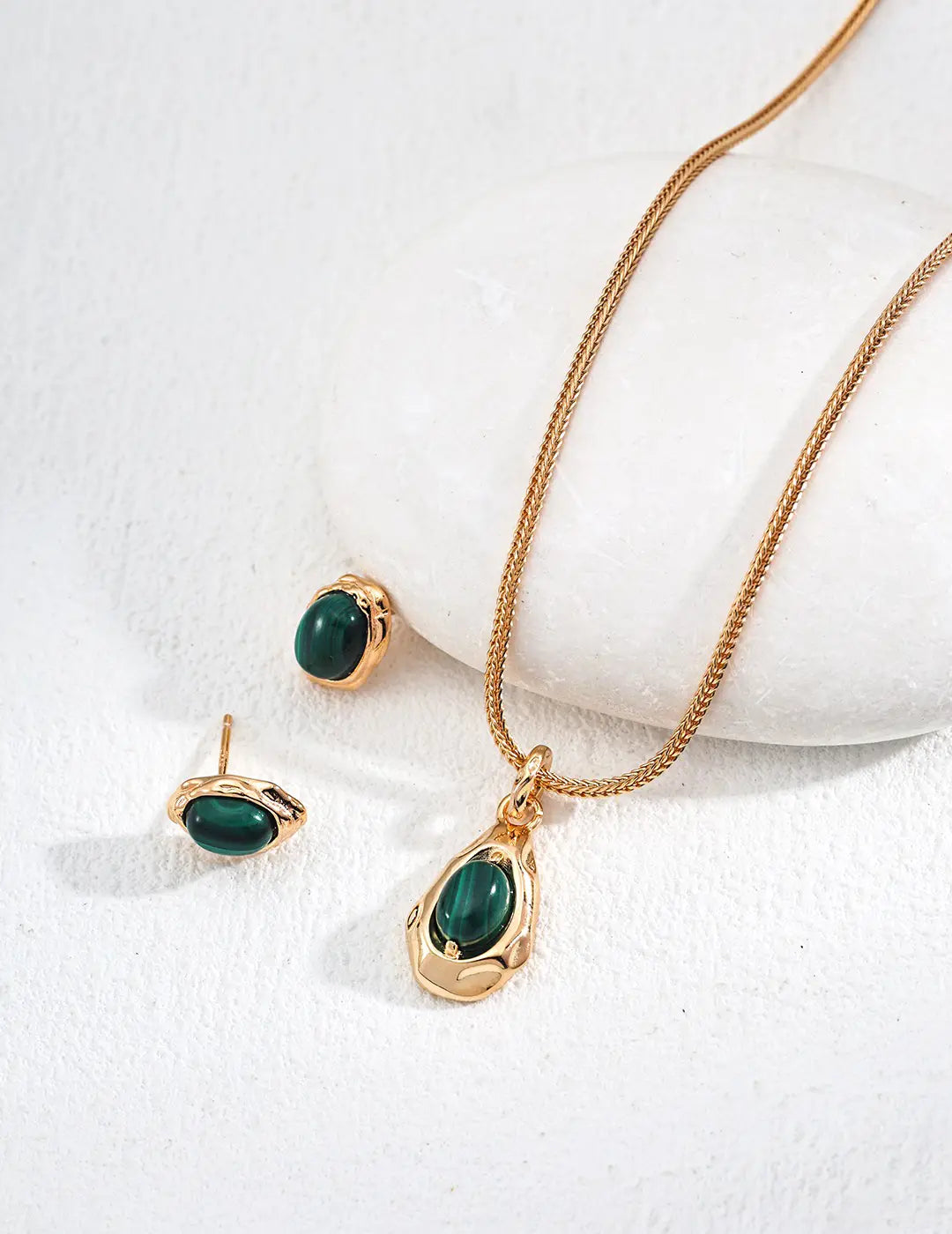 Delicate gold necklace with green emerald pendant from Anaïs & Aimee’s luxury collection.