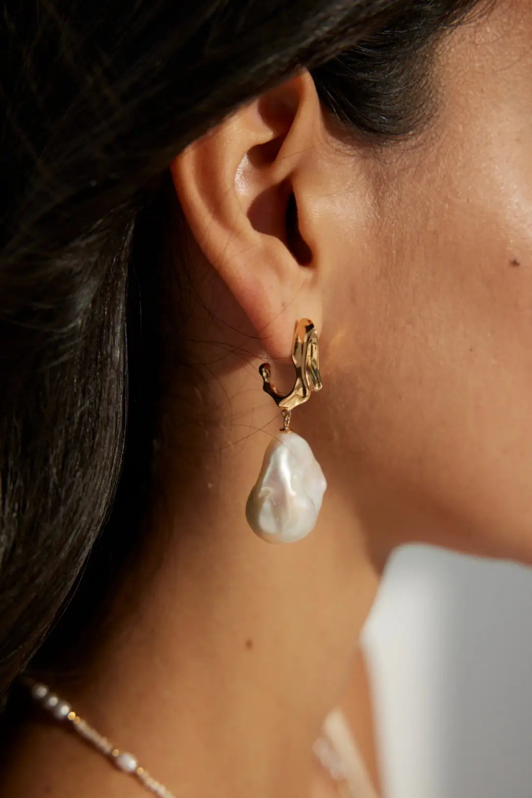 Close-up of Lumière Baroque Pearl Earrings with silver-gold tops and natural pearls