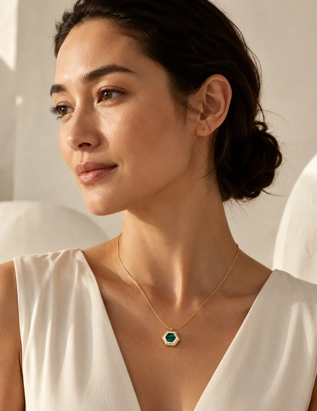 Elegant portrait of a woman wearing the Malachite Pendant Necklace, featuring a green malachite gemstone pendant set in vintage gold plating.