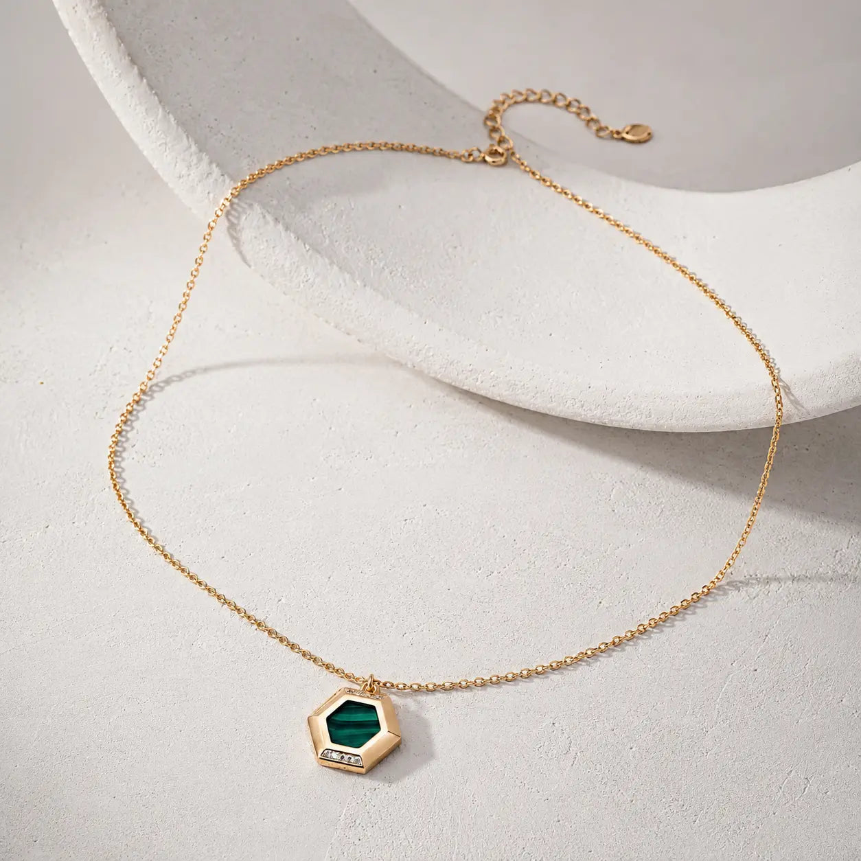 Malachite Pendant Necklace featuring a vintage gold hexagon pendant with natural green malachite stone and white zircon detail on a warm studio background.