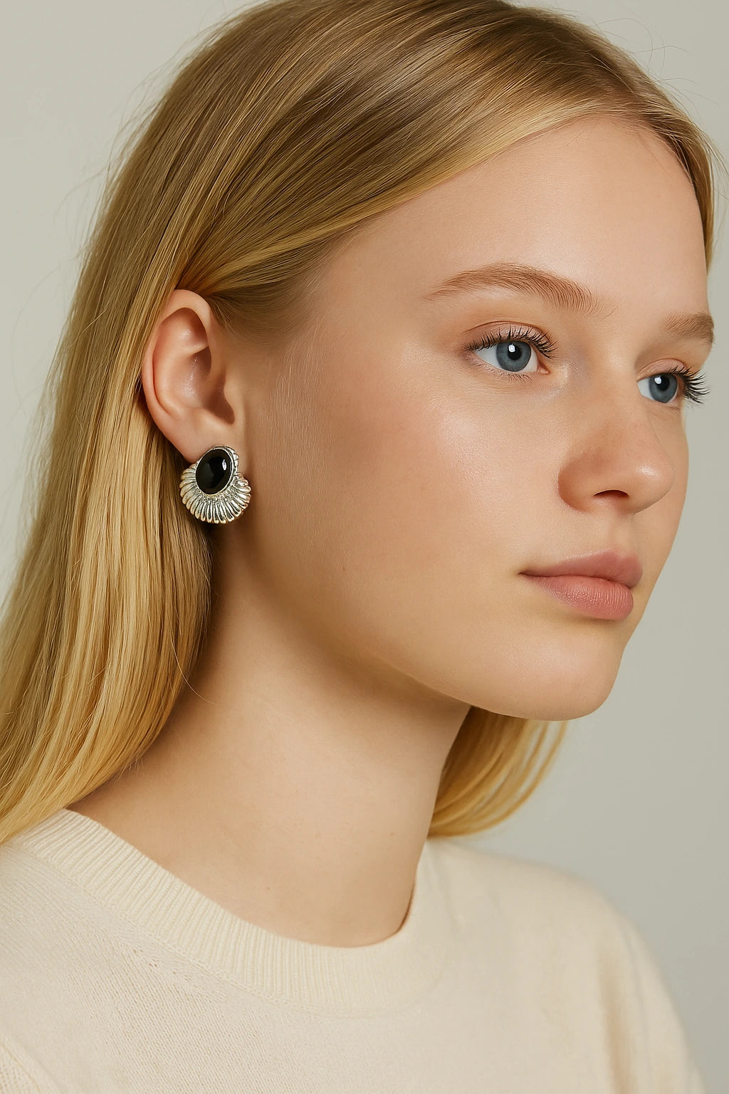 45° portrait of young blonde woman wearing vintage silver earrings with black onyx stones