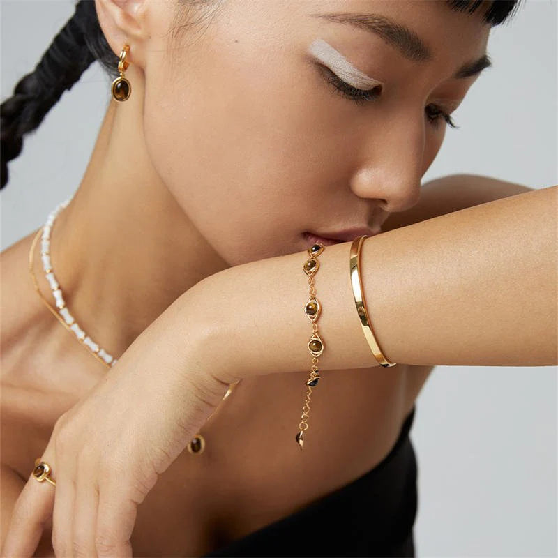 Side view of Anaïs & Aimee Tiger Eye Earrings with gold finish and natural gemstone design.