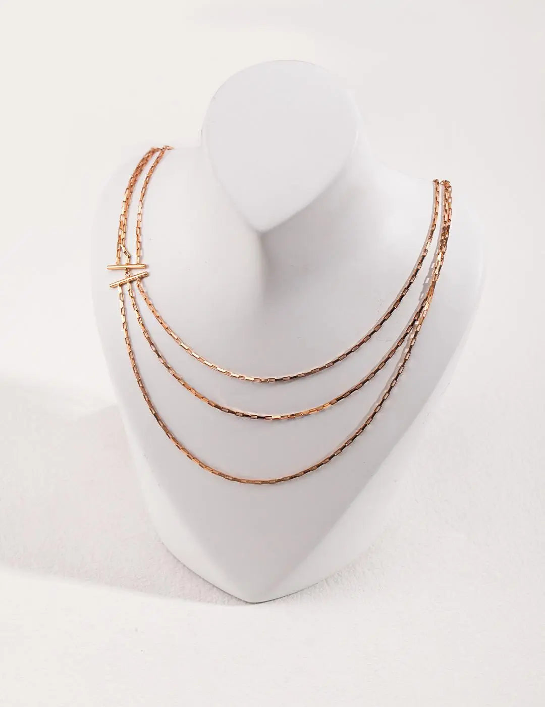 gold necklace on a white mannequin bust