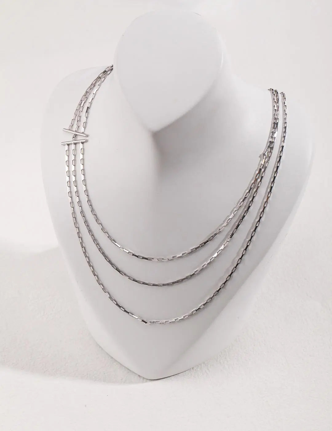Set of silver hoop earrings on a white mannequin head.