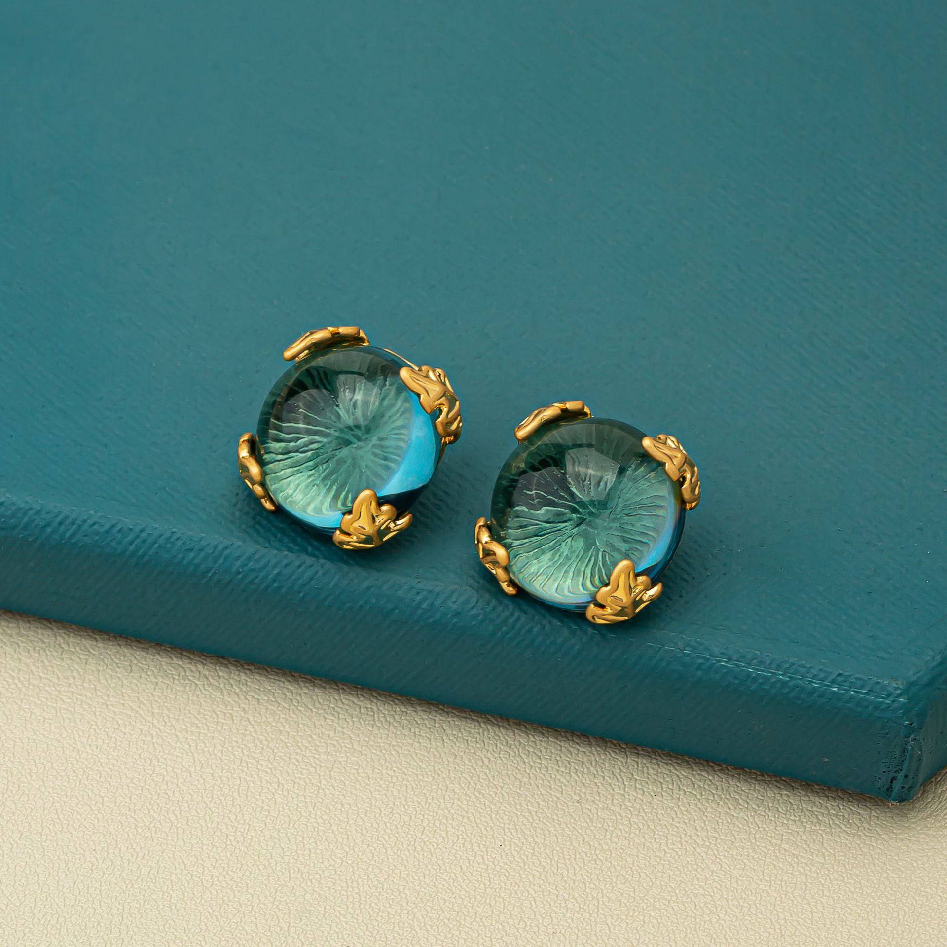 Green crystal cascade chandelier earrings with gold-tone prongs, luxury style.