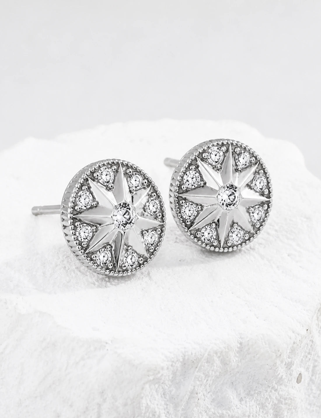 Didcot sterling silver starburst stud earrings with cubic zirconia, viewed from the left