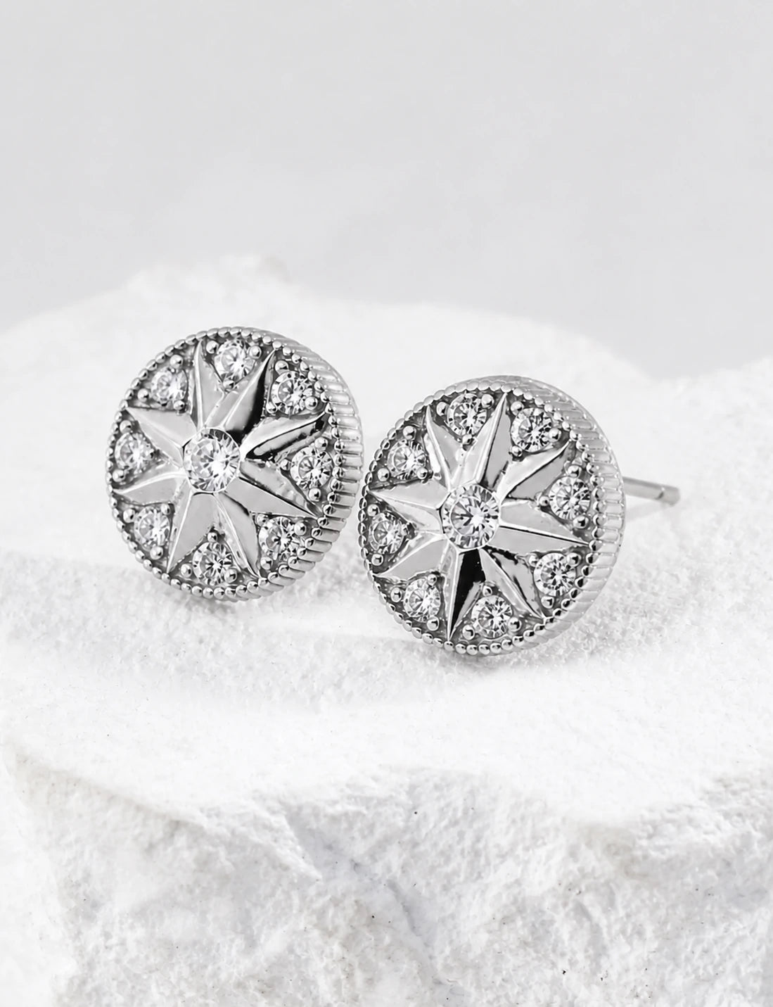 Pair of Didcot sterling silver stud earrings with starburst details and clear cubic zirconia, front view