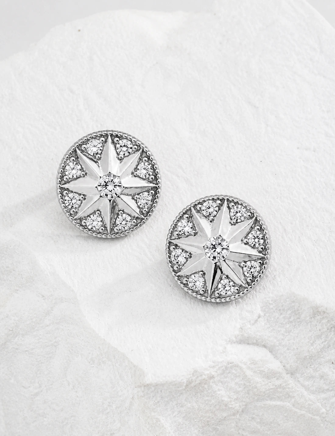Pair of Didcot sterling silver starburst stud earrings arranged face-up in a top-down view