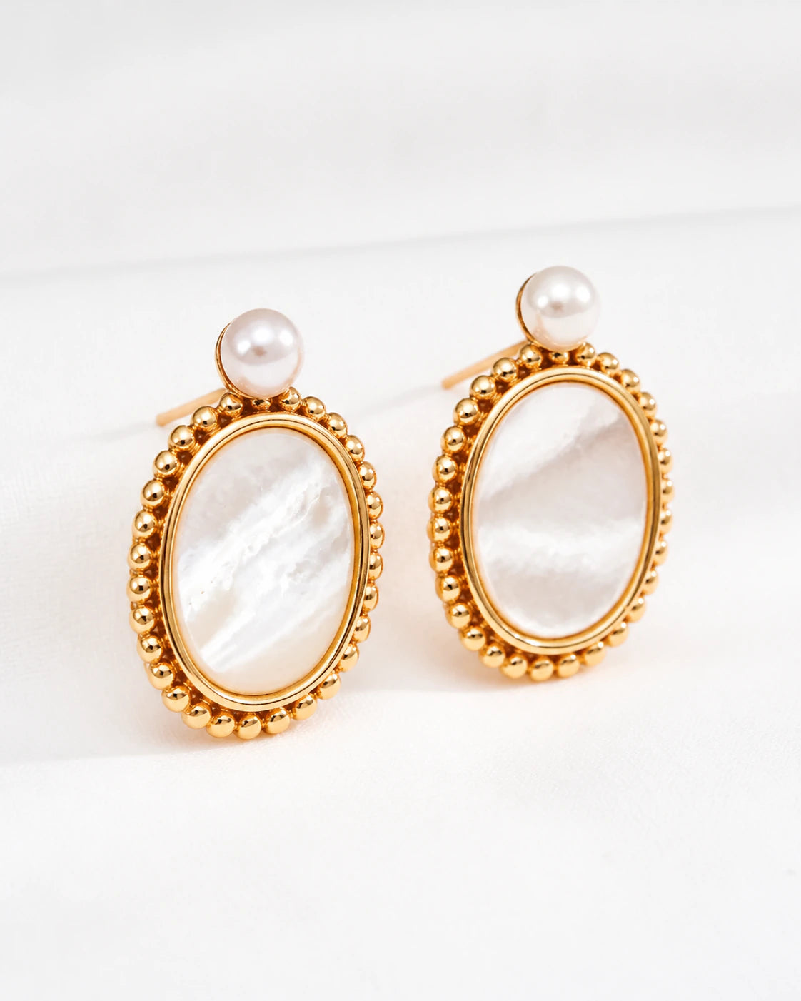 Haslemere gold vermeil mother of pearl drop earrings with pearl studs, shown from the left three-quarter angle