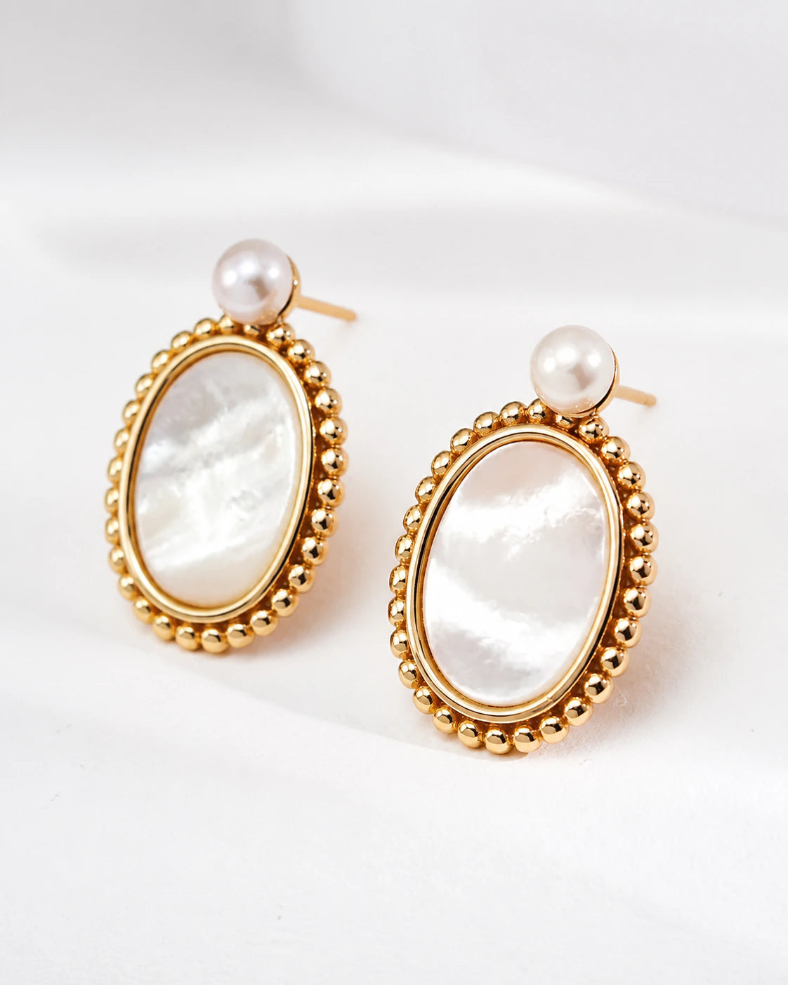 Haslemere gold mother of pearl drop earrings with pearl studs, shown from the right three-quarter angle