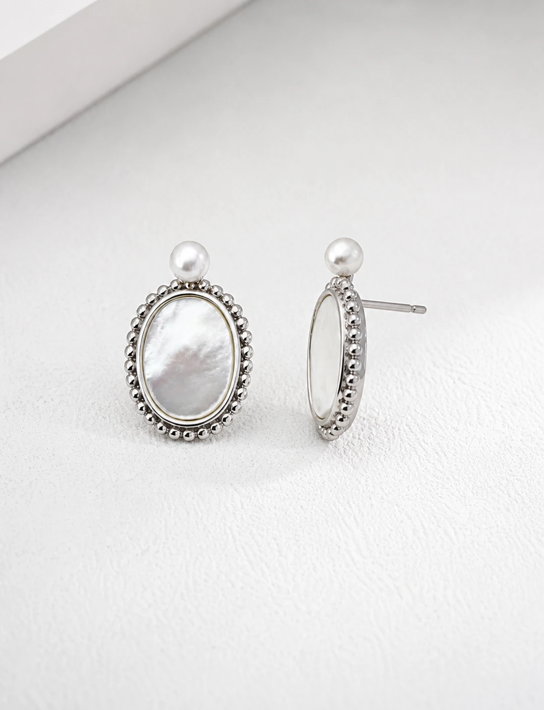 Haslemere silver mother-of-pearl drop earrings shown from the front and side with pearl studs and beaded oval frames