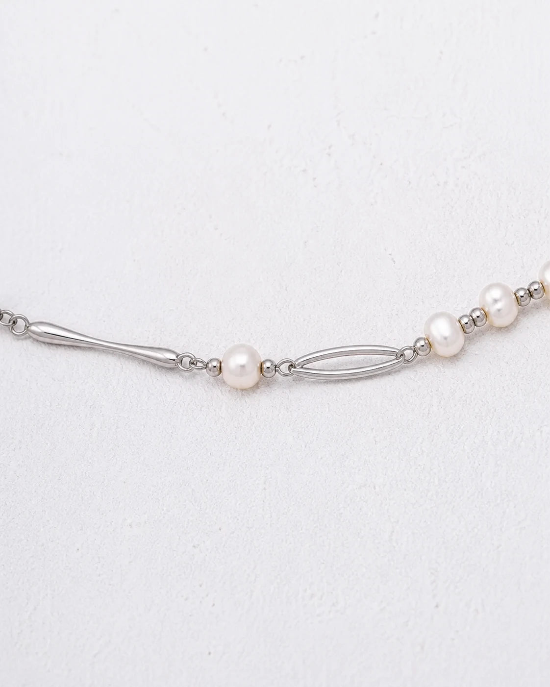Dainty silver freshwater pearl necklace with decorative links, right three-quarter view
