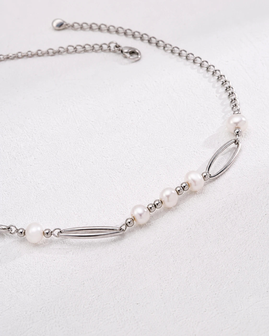 Sterling silver freshwater pearl necklace with oval links and bar details, close-up